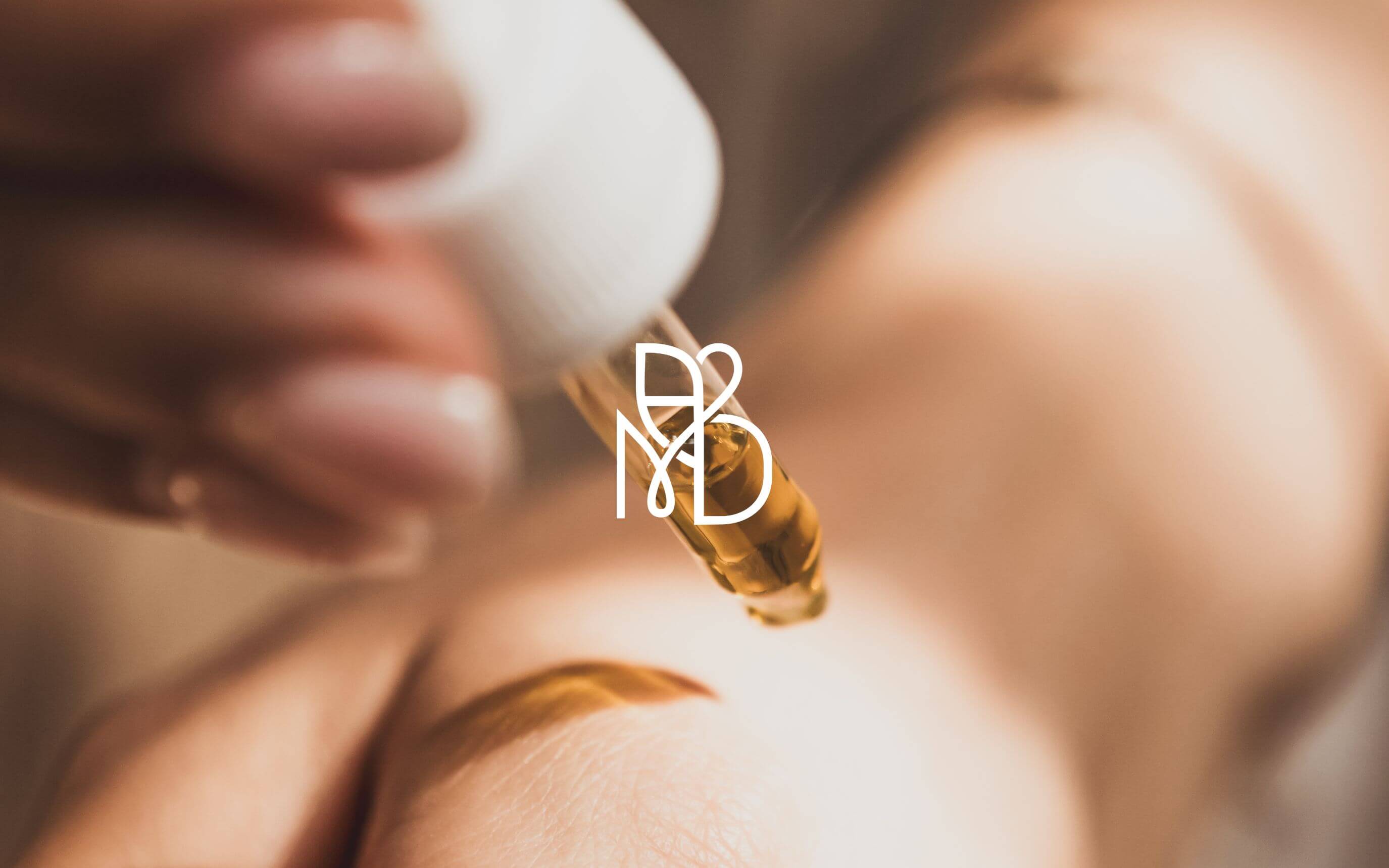 A woman dropping Amour de Moi Skincare youth preserving serum to her hand with a dropper