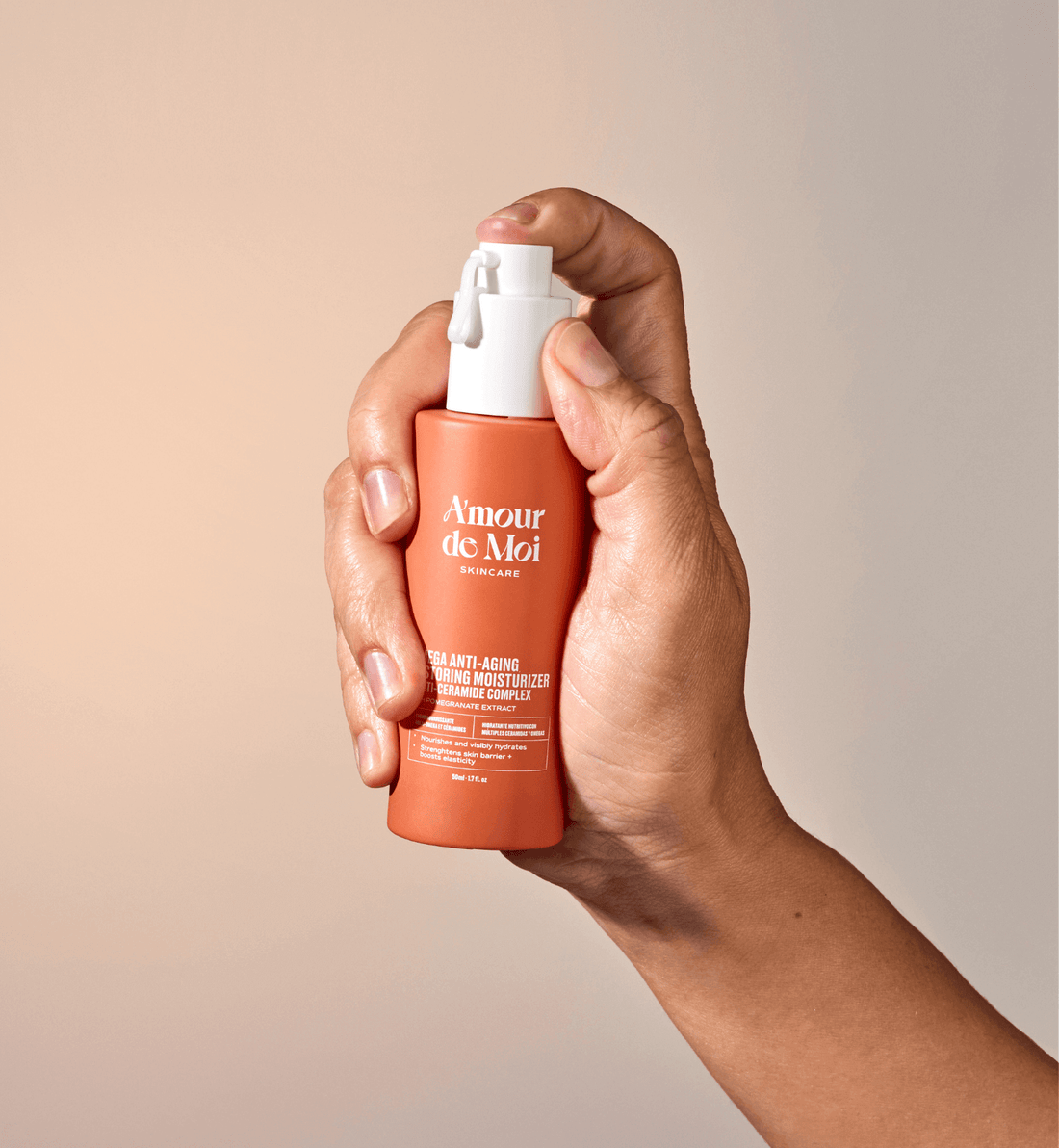 Woman holding and pressing a bottle of anti-aging multi ceramide omega skin restoring moisturizer
showcasing product