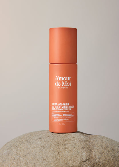 A bottle of multi-ceramide complex omega anti-aging restoring moisturizer sitting on a rock