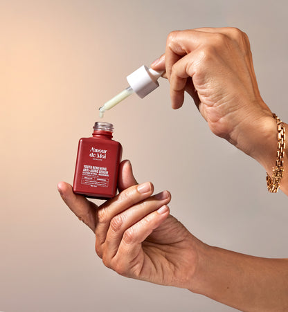 Woman holding and opening a bottle of anti-aging retinol niacinamide youth preserving serum showcasing product