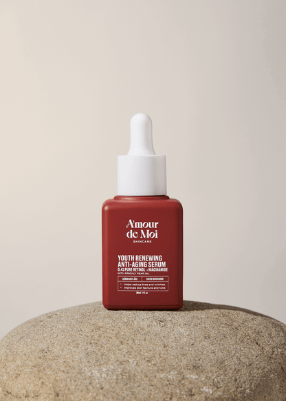 A bottle of youth renewing anti-aging serum sitting on a rock