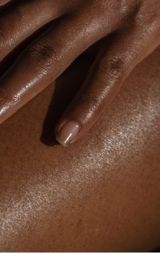 Close up of African American woman's hand on her skin