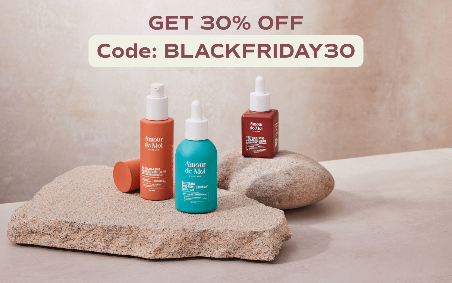 All three amour de moi skincare products sitting on rocks being showcased